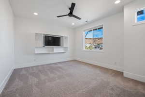 Carpeted spare room with ceiling fan