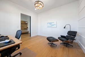 Office area featuring light hardwood / wood-style floors and a notable chandelier