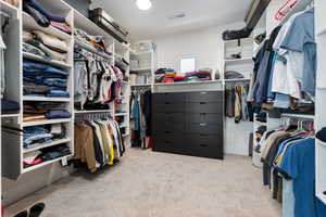 Walk in closet with light carpet