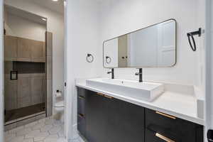 Bathroom featuring vanity, tile patterned floors, a stall shower, and toilet