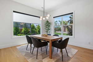 Dining area with an inviting chandelier, baseboards, light wood-type flooring, and visible vents