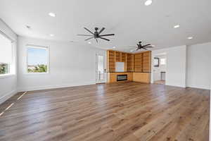 Unfurnished living room featuring recessed lighting, a ceiling fan, visible vents, and wood finished floors