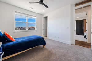 Bedroom with a barn door, carpet floors, and ceiling fan