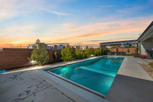 Pool at dusk featuring a pergola and a patio area