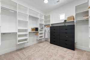Walk in closet featuring visible vents and carpet flooring