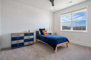 Carpeted bedroom featuring ceiling fan