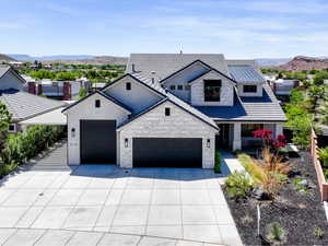Modern farmhouse style home with a garage, a mountain view, driveway, and stone siding