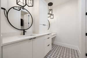 Bathroom featuring baseboards, vanity, and tile patterned floors