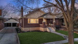 Bungalow-style house with a carport, a porch, and a lawn