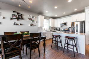 Kitchen featuring white cabinetry, appliances with stainless steel finishes, and a kitchen island