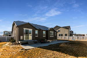 Back of house with a patio and a lawn