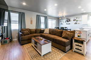 Living room with a chandelier, light hardwood / wood-style flooring, and a textured ceiling
