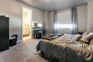 Carpeted bedroom featuring ensuite bath