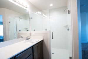 Bathroom featuring vanity and an enclosed shower