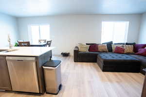 Living room featuring sink, light hardwood / wood-style floors, and a textured ceiling