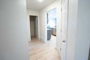 Corridor featuring sink and light wood-type flooring