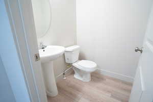 Bathroom featuring hardwood / wood-style floors, sink, and toilet