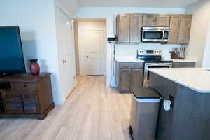 Kitchen featuring stainless steel appliances and light hardwood / wood-style floors