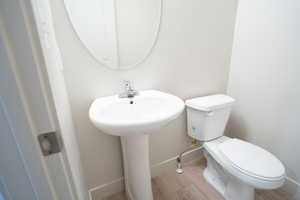 Bathroom with hardwood / wood-style floors and toilet