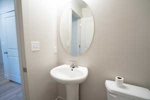 Bathroom featuring hardwood / wood-style floors and toilet