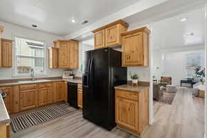 Kitchen with sink, black appliances, and light wood-type flooring