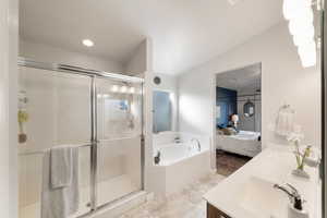 Bathroom featuring vanity and shower with separate bathtub