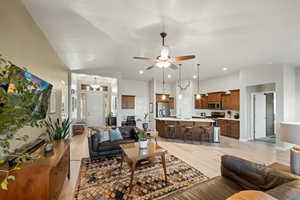 Living room featuring vaulted ceiling, sink, ceiling fan, and light hardwood / wood-style floors