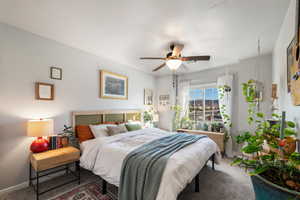 Carpeted bedroom with a textured ceiling and ceiling fan