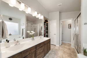 Bathroom featuring vanity and a shower with door