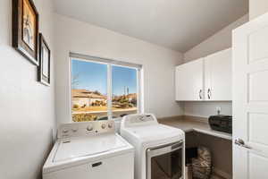 Washroom with cabinets and washer and clothes dryer