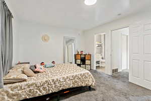 Carpeted bedroom featuring ensuite bathroom