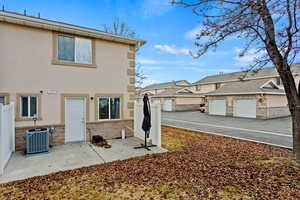 Rear view of house with a garage and central AC unit