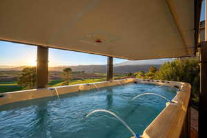 View of swimming pool featuring a hot tub and a mountain view