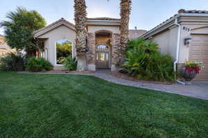 Mediterranean / spanish-style home with a garage and a front lawn