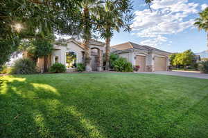 Mediterranean / spanish-style home with a garage and a front lawn