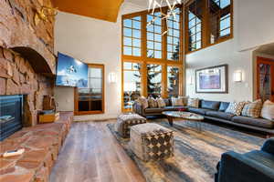 Living room featuring wood-type flooring, a notable chandelier, and a fireplace