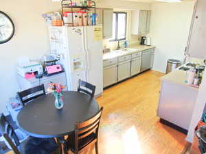 Kitchen with sink, gas cooktop, white refrigerator with ice dispenser, light hardwood / wood-style floors, and stainless steel dishwasher