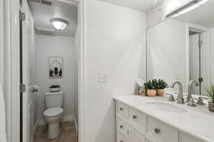 Bathroom with tile patterned floors, toilet, vanity, and a textured ceiling