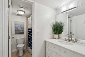 Bathroom featuring vanity, a textured ceiling, tile patterned floors, and toilet