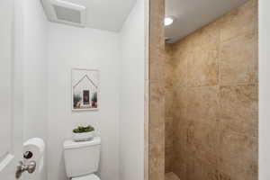 Bathroom featuring toilet and tiled shower