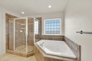 Bathroom featuring shower with separate bathtub and tile patterned flooring