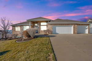 View of front of property with a garage and a lawn