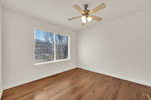 Empty room with ceiling fan and wood-type flooring