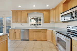 Kitchen with plenty of natural light, stainless steel appliances, sink, and light brown cabinets