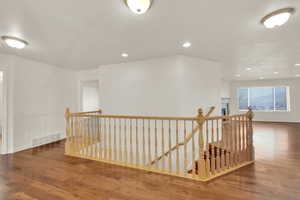 Corridor with hardwood / wood-style flooring and a textured ceiling