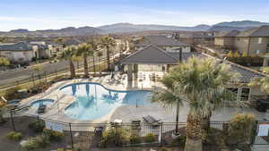 View of pool with a hot tub, a patio, and a mountain view