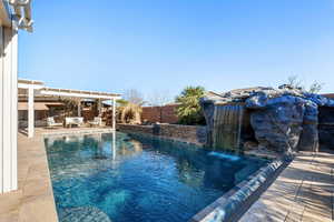 View of swimming pool with a patio and pool water feature