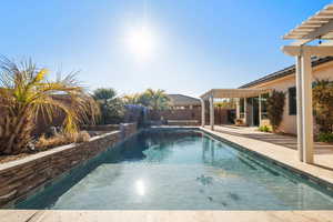 View of pool featuring pool water feature, a pergola, and a patio