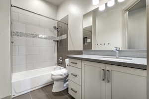 Full bathroom featuring tiled shower / bath, vanity, and toilet