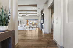 Hallway featuring a tray ceiling and dark wood-type flooring